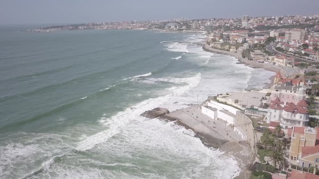 Aerial panoramic view of Estoril in Cascais, Lisbon, Portugal with drone flying backwards and views toward the beach and ocean