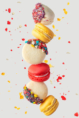 Colorful macarons cookies. French cakes. Sweet and colorful French macaroons fall or fly in motion. With slices