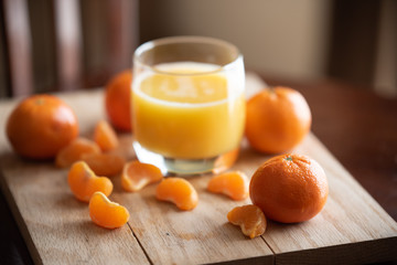 A glass of orange juice with clementine oranges 