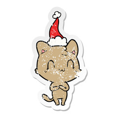 distressed sticker cartoon of a happy cat wearing santa hat