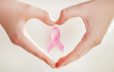Obraz premium Hands making a heart shape with a pink ribbon, breast cancer awareness concept