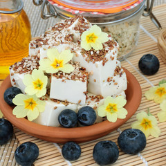 Vegan health food with tofu bean curd dusted with alfalfa and sesame seed & ground pepper, primrose flowers, hemp husks, olive oil & blueberries. High in protein, omega 3 &  antioxidants.