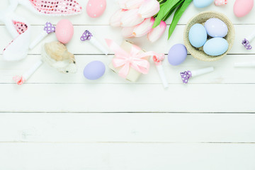 Obraz na płótnie Canvas Table top view shot of decorations Happy Easter holiday background concept.Flat lay bunny eggs with tulip and variety decor for season on modern rustic white wooden.Blank space design for mock up.