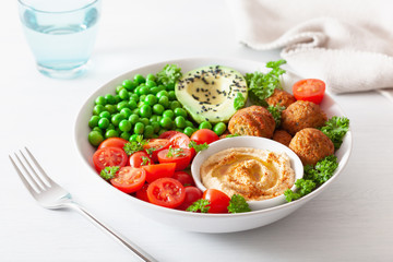 healthy vegan lunch bowl with falafel hummus tomato avocado peas