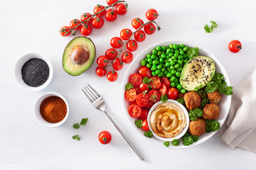 healthy vegan lunch bowl with falafel hummus tomato avocado peas