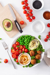 healthy vegan lunch bowl with falafel hummus tomato avocado peas