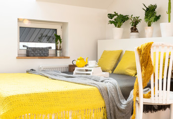 Modern interior of bedroom with bed and pillows in yellow colours