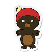 sticker of a cartoon cute black bear in hat