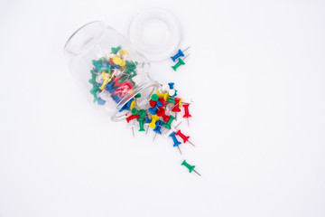 The colorful push pins and glass bottle put on white background,the office supply