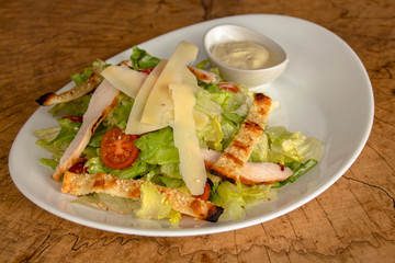 Green salad with cherry tomatoes, chicken roll, parmesan cheese and crunchy pieces of arabic bread with sesame. Garnished with mayonnaise dressing.