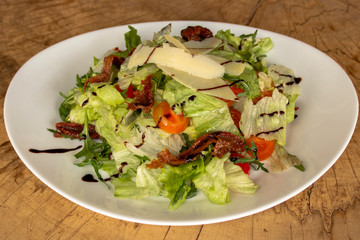 Salad with arugula, iceberg lettuce, dried and cherry tomatoes,parmesan cheese and balsamic dressing.