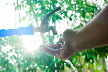 Hand washing on blur green nature background, Water energy conservative concept, Clean hand by...