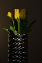Yellow tulips in metal vase