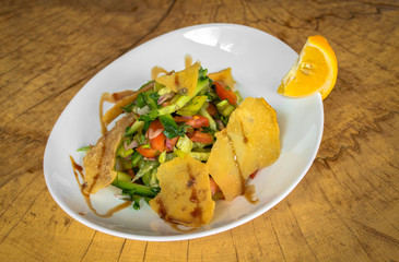 Salad with cucumbers and tomatoes diced, green pepper, onion, parsley, crunchy Arabian chips, garlic and pomegranate juice. Garnished with slice of lemon.