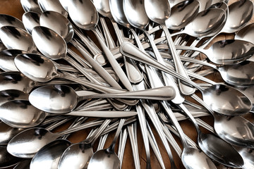 Stack of shining spoon, Abstract background of  sparkling bronze spoon, kitchen equipment, Row of silver spoon background, Glittering light from kitchen equipment