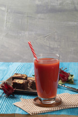 close up of Roselle juice and brownie cake on wooden blue background