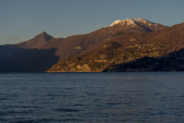 Fototapeta na wymiar Italy, Lecco, Lake Como, a large body of water with a mountain in the background