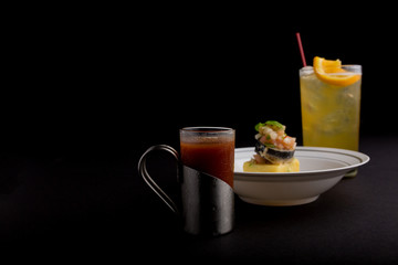 Cocktail and appetizer on black background