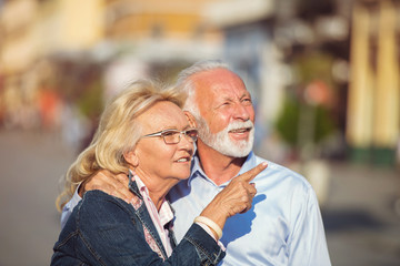 Happy nice mature couple walking in town