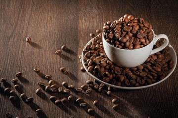 A white cup filled with natural roasted coffee beans.