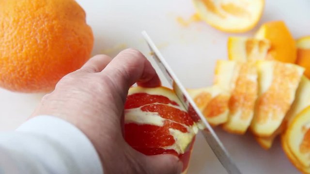 Removing pith from orange, then cutting it into round slices