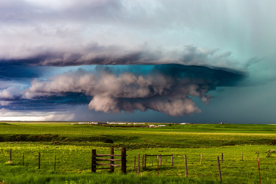 Dramatic green storm clouds from a supercell thunderstorm over a field