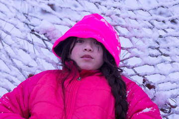 Young Asian girl laying in the snow
