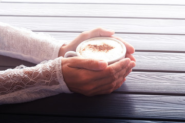 women holding  hands cup coffee