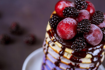 Delicious pancakes with grape, berry jam on wooden table