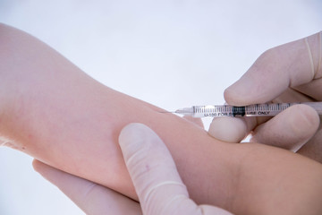 Hand with syringe for injection. Vaccination against influenza and virus. Insulin syringe with thin needle. The baby is ready for vaccination.