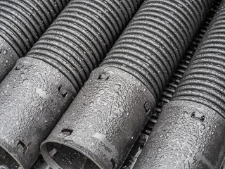 Black plastic pipes of various diameters in a row