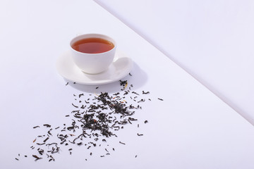 Ceramic cup with tea and tea leaves, on a white background. The harsh shade of the sun, the art...