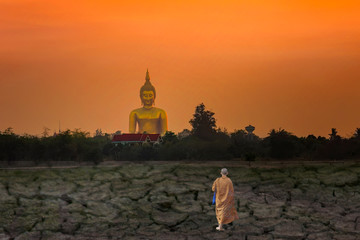 Monks walk to find a large Buddha.