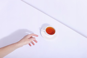 Ceramic cup with tea, on a white background. The harsh shade of the sun, the art concept of the...