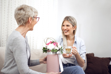 Middle-aged lady got beautiful flowers from her daughter.