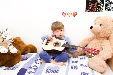 Ein kleiner Junge spielt auf einer Gitarre