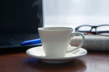 Newspaper with computer on table. Coffee break.