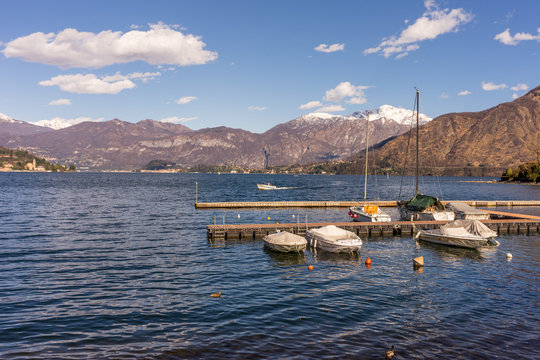 Italy, Lecco, Lake Como, a small boat in a body of water with a mountain in the background