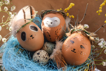 Easter holiday concept with cute handmade eggs, rabbit, chicks, owl, panda and deer. Creative eggs for Easter. Happy easter