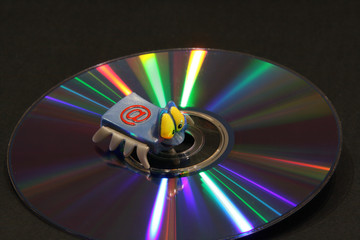 CD with color beams and electronic key on a dark background. Correction fluid,electronic key, DVD with color rays of a rainbow, a notebook,record marker  and a pen on a dark background