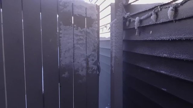 Ice crystals forming on backyard entrance and house wall