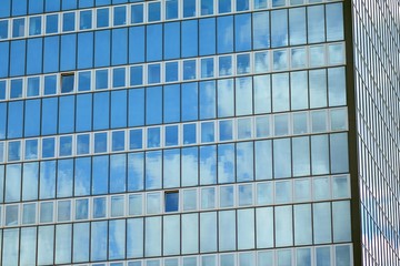 Surface of glass building with the reflection of clouds