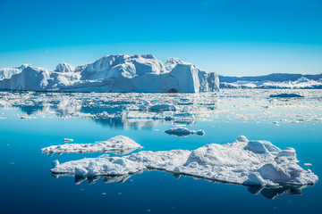Icebergs off the glacier flowing on the open ocean near Ilulissat icefjord, Greenland - obrazy, fototapety, plakaty