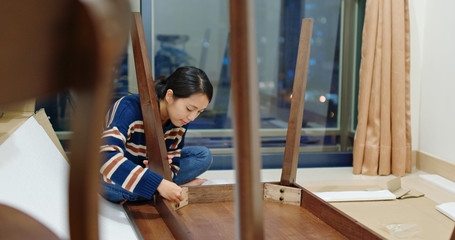 Woman assemble the table at home