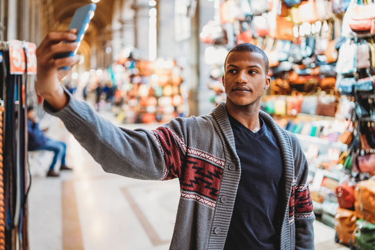 Young man takes a selfie in a market in Florence, Italy