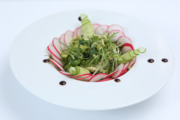 restaurant dish, green salad with radishes, arugula and cucumbers, healthy food, for the menu