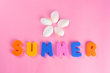 Word SUMMER letters and seashell or sea shell on pink textured background. Original idea from natural material for summer design. Flat lay.