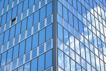 Fototapeta na wymiar Surface of glass building with the reflection of clouds