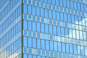 Surface of glass building with the reflection of clouds