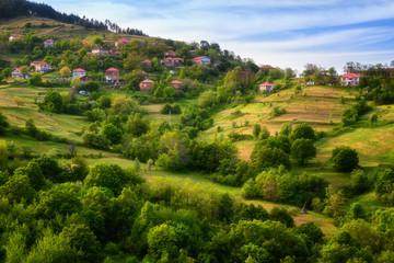 Spring is coming... Amazing spring view with a little village in Rhodopi Mountains, Bulgaria. Magnificent landscape, green fields, small houses.